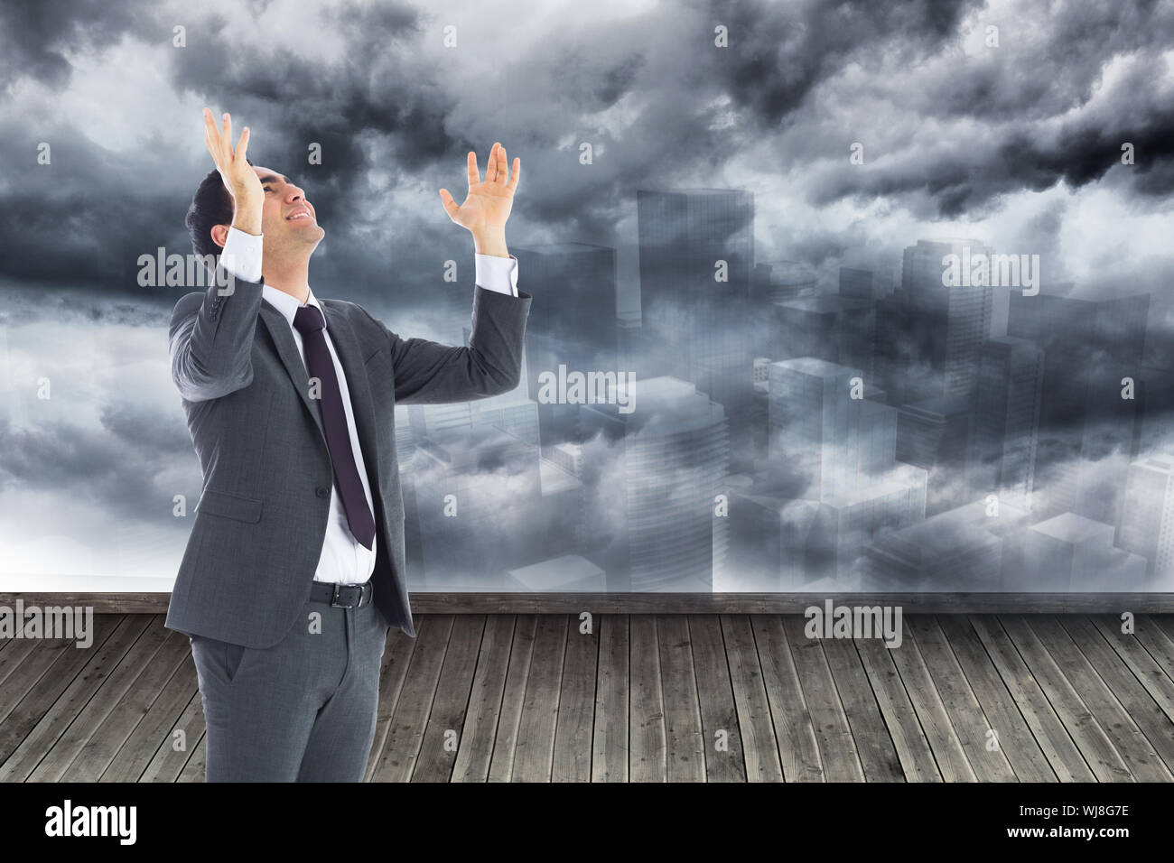 Composite image of happy businessman with arms raised Stock Photo - Alamy