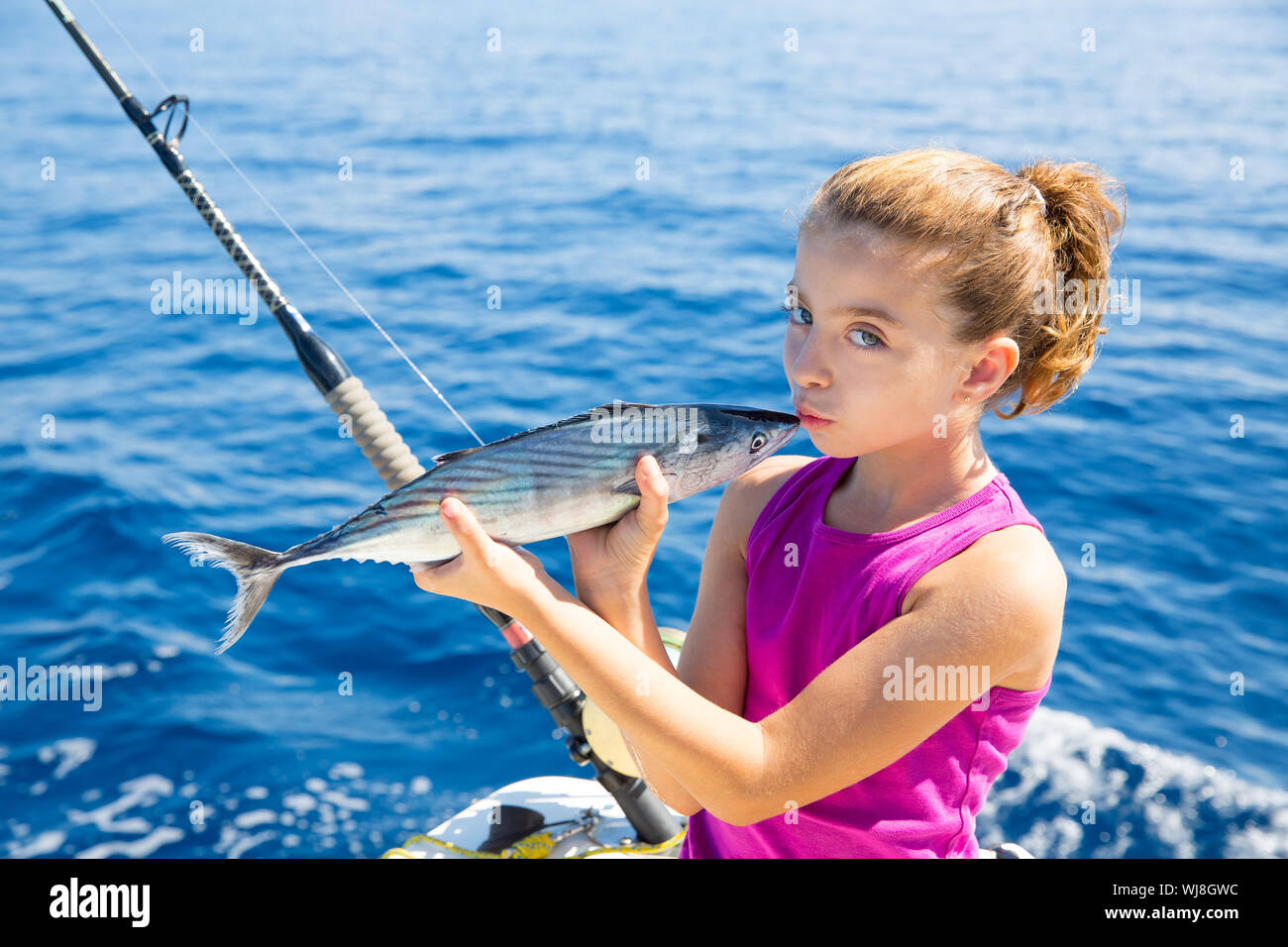 kid girl fishing tuna bonito sarda kissing fish for release due little size Stock Photo