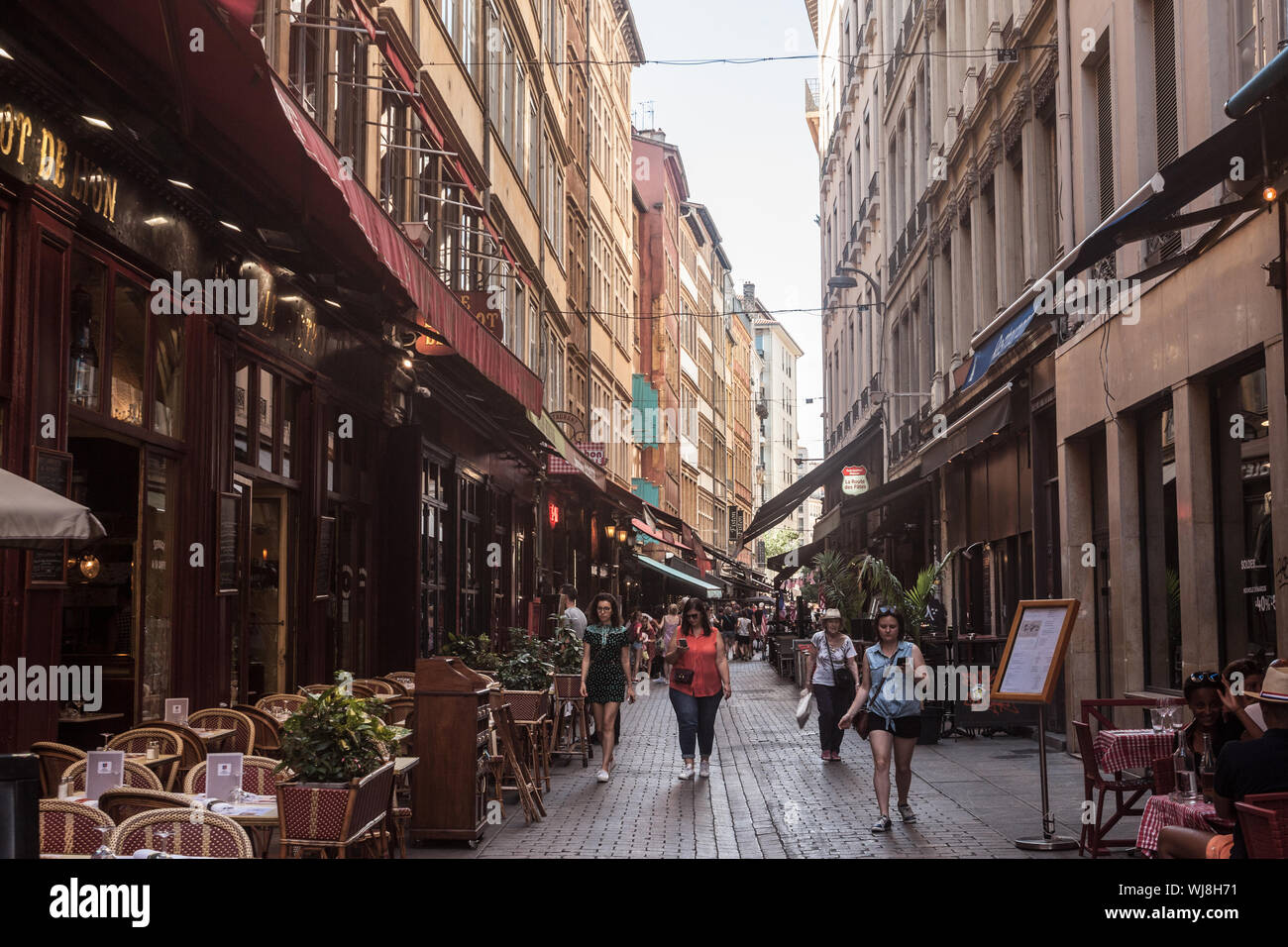 LYON, FRANCE - JULY 13, 2019: Tourists walking in Typical street of the Vieux Lyon (old Lyon) on the Presqu'ile district with tourists passing by near Stock Photo