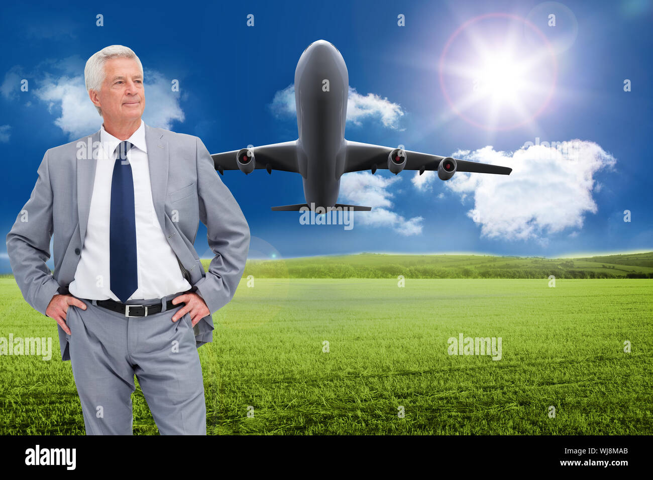 Composite image of man in a suit with his hands on his hips against white background Stock Photo