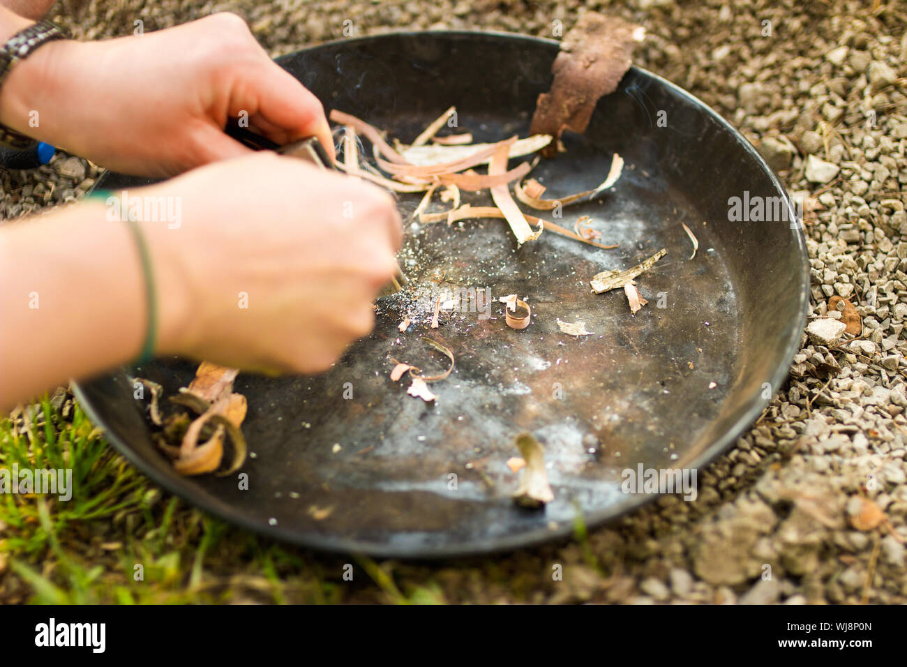 Close-up Of Hands Kindling A Fire With Natural Material Stock Photo