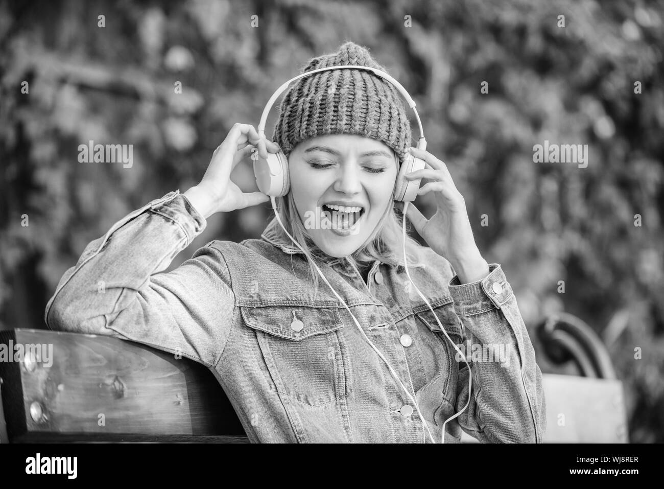 happiness. audio book. style and music. hipster woman in headphones. modern technology instead of reading. relax in park. hipster girl with mp3 player. listening music in park. E-learning concept. Stock Photo