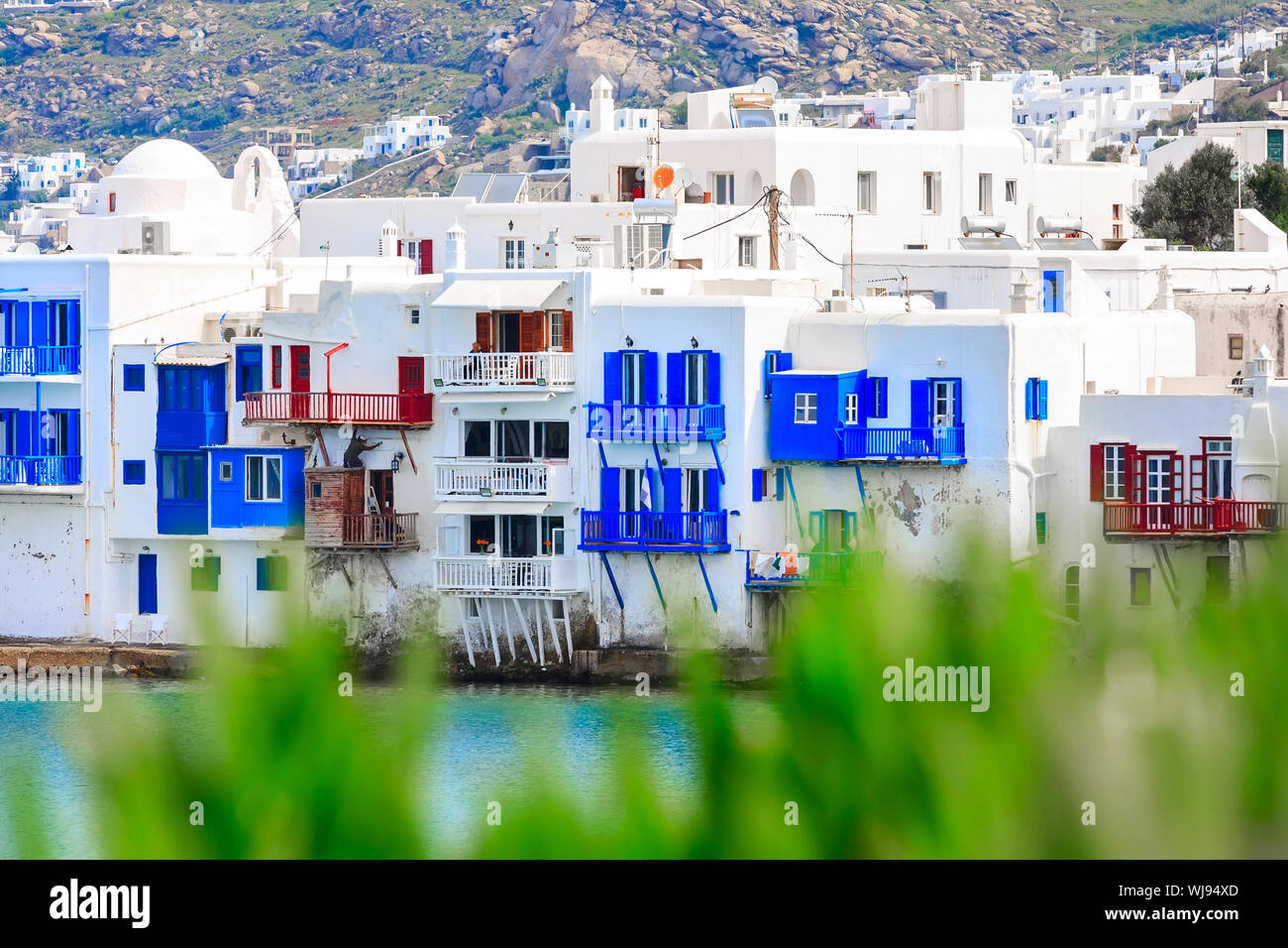 Mykonos, Greece aerial panoramic view of Little Venice traditional houses, white church and green plants Stock Photo
