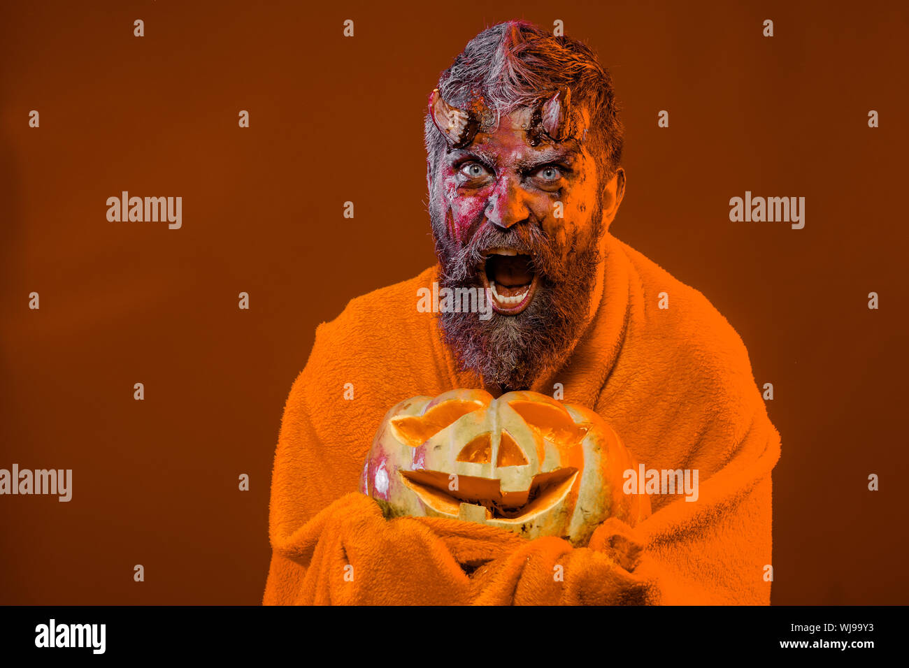 Halloween satan surprised with bloody horns, beard, blood, wounds Stock