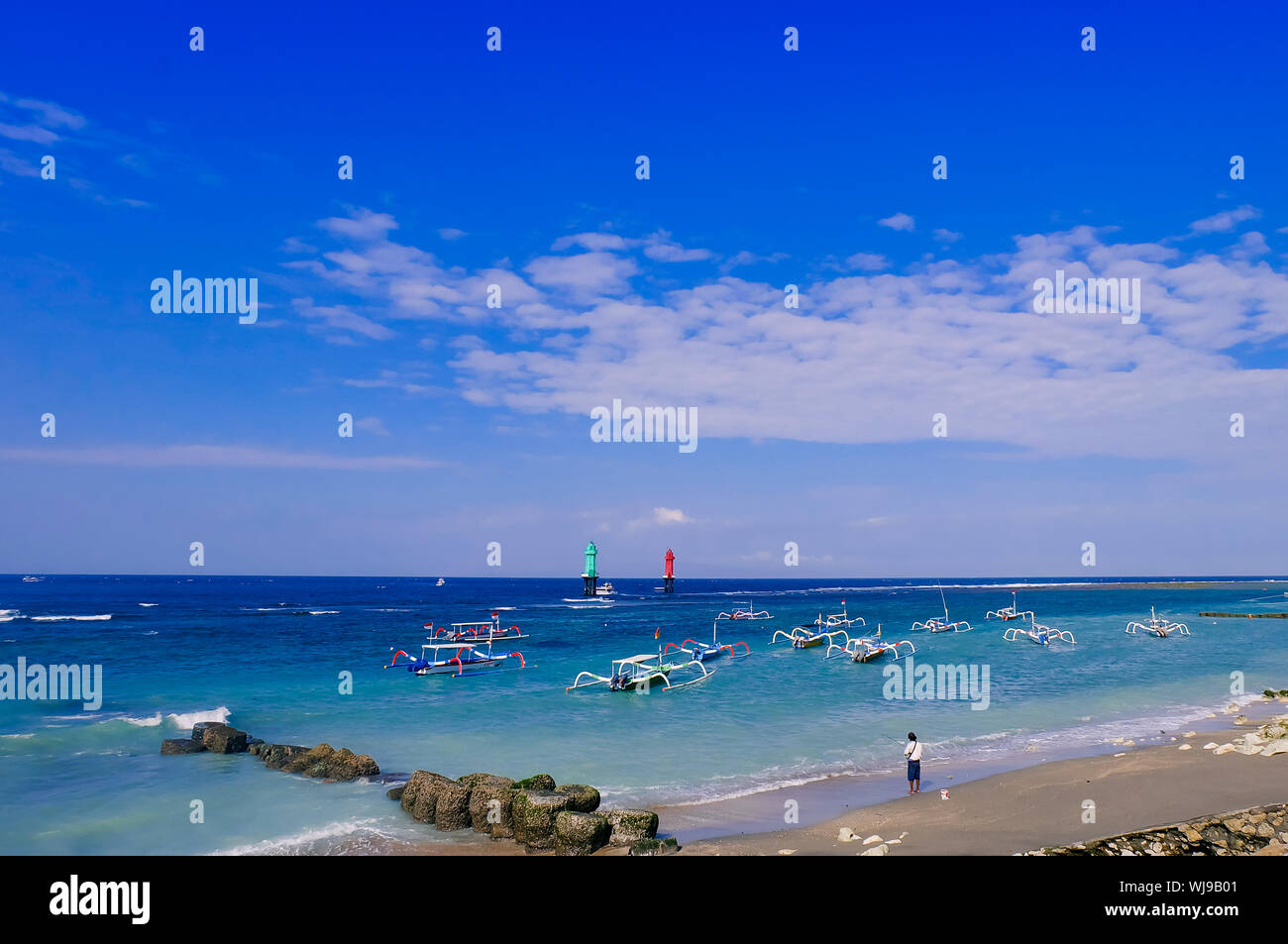 Landscape of beautiful beach. Fishing man on Sanur port, Bali, Indonesia. Royalty high quality stock image of landscape. Stock Photo