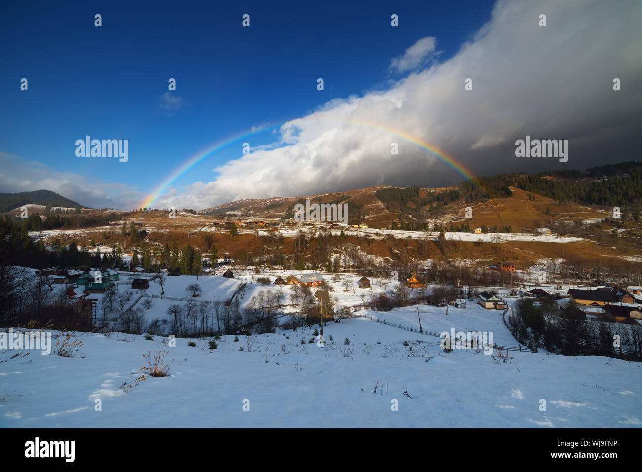 Winter rainbow. Mountain village. Beauty in nature. Carpathians, Ukraine, Europe Stock Photo