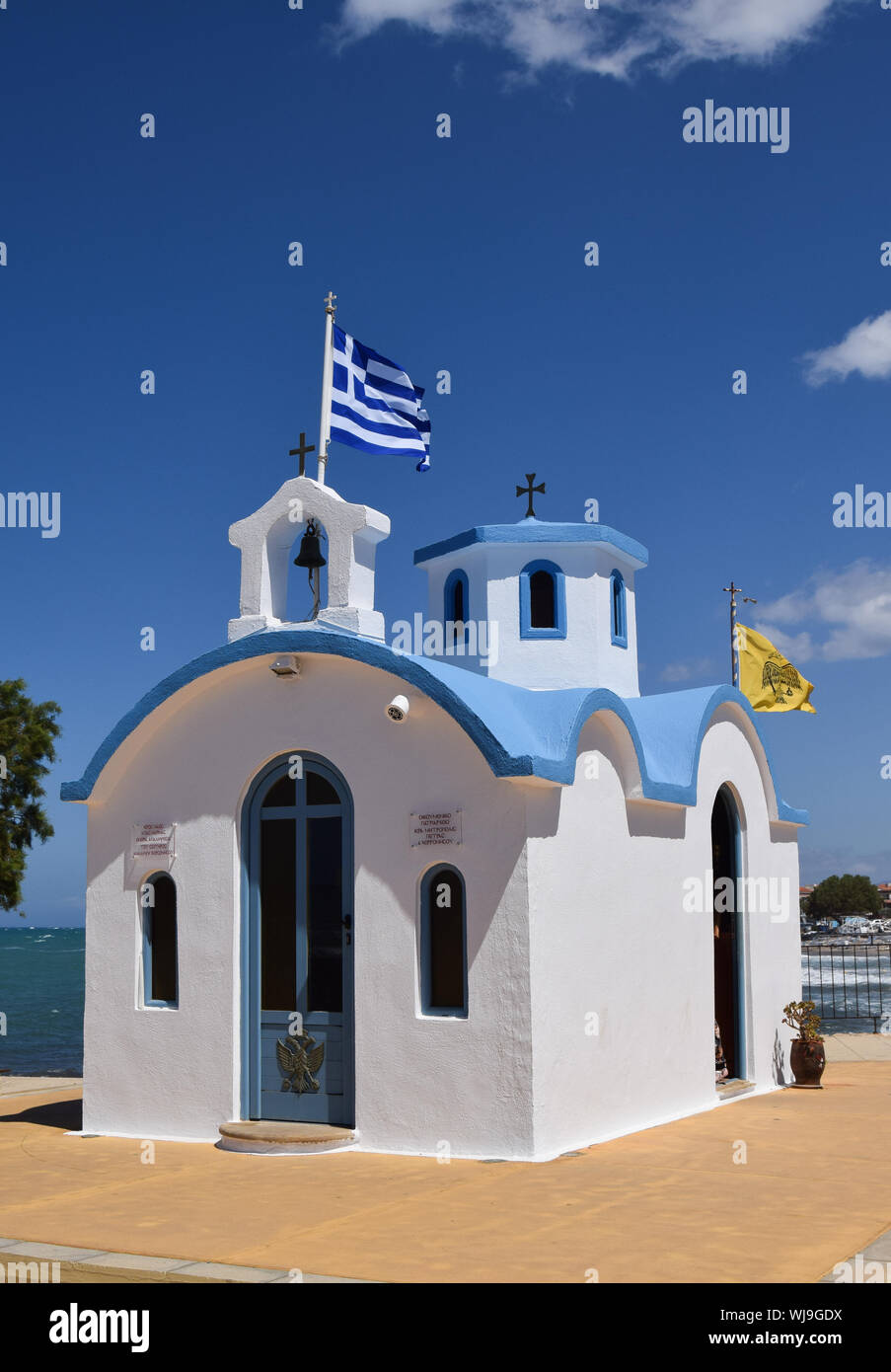 Greece Flag On Church Against Sky Stock Photo