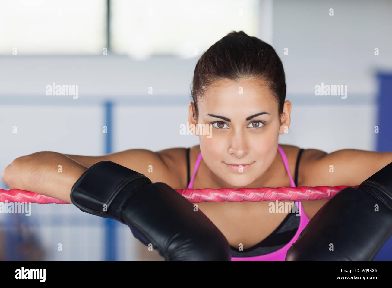 Closeup portrait of a beautiful young woman in black boxing gloves