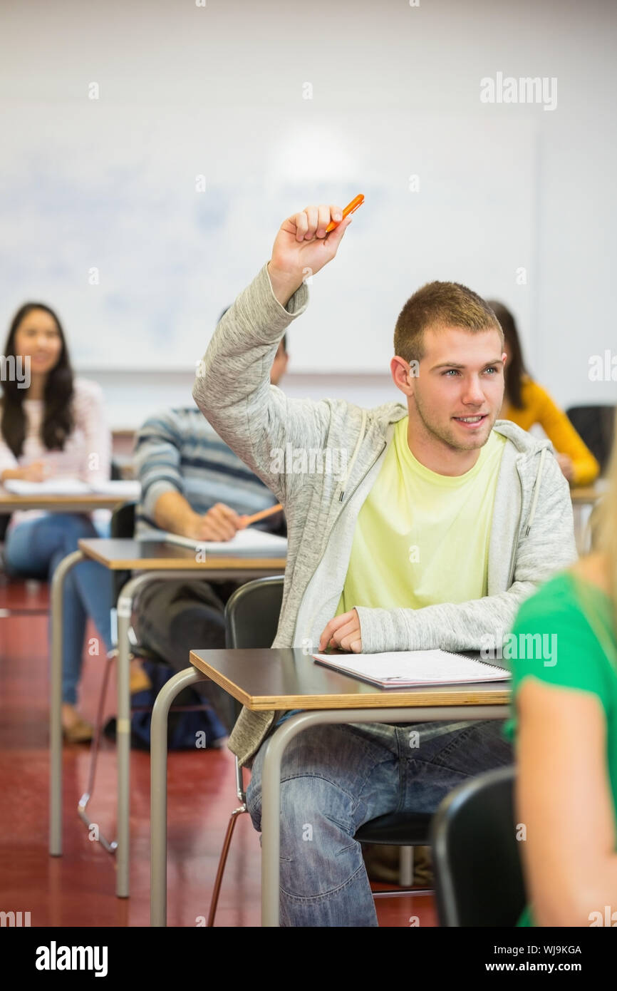 Young male student raising hand by others in the college classroom Stock  Photo - Alamy, image size:866x1390