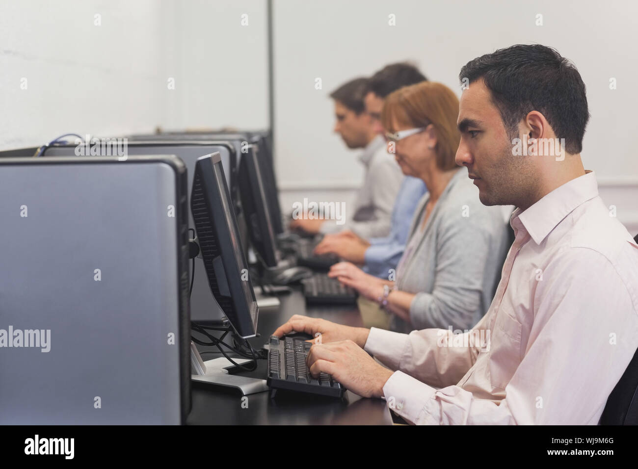 Mature students sitting in computer class working on computers Stock Photo