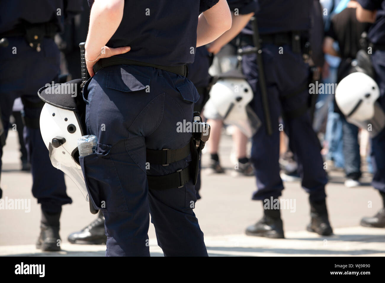 Rear View Midsection Of Female Police Officer Standing With Hand On Hip Stock Photo