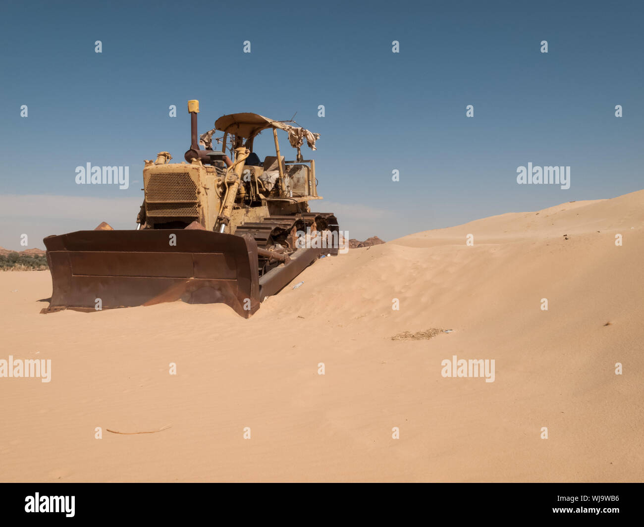 An old bulldozer abandoned in the middle of the desert in Saudi Arabia. Construction machinery Stock Photo