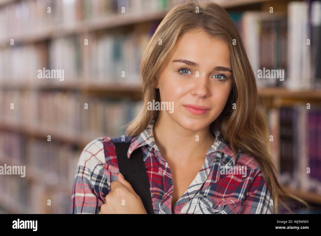 Pretty smiling student looking at camera in library Stock Photo - Alamy