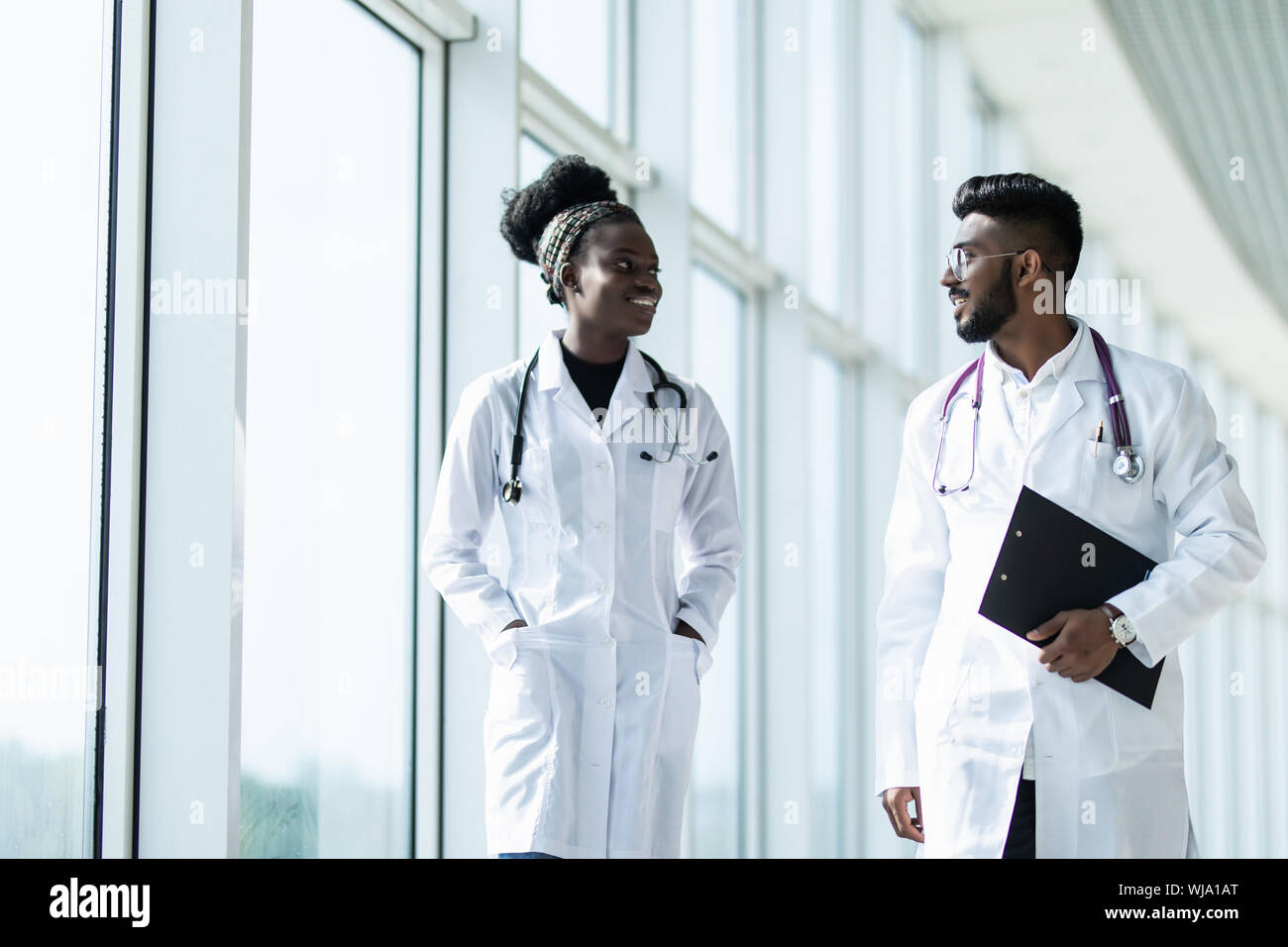 Two doctors discussing diagnosis while walking Stock Photo