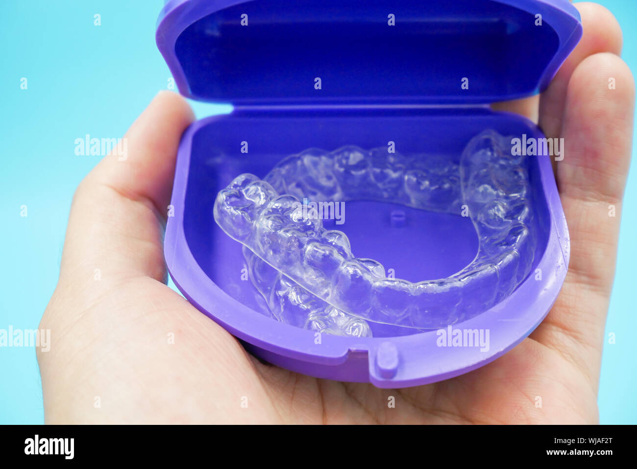clear plastic retainer teeth in the box set isolated on blue sky