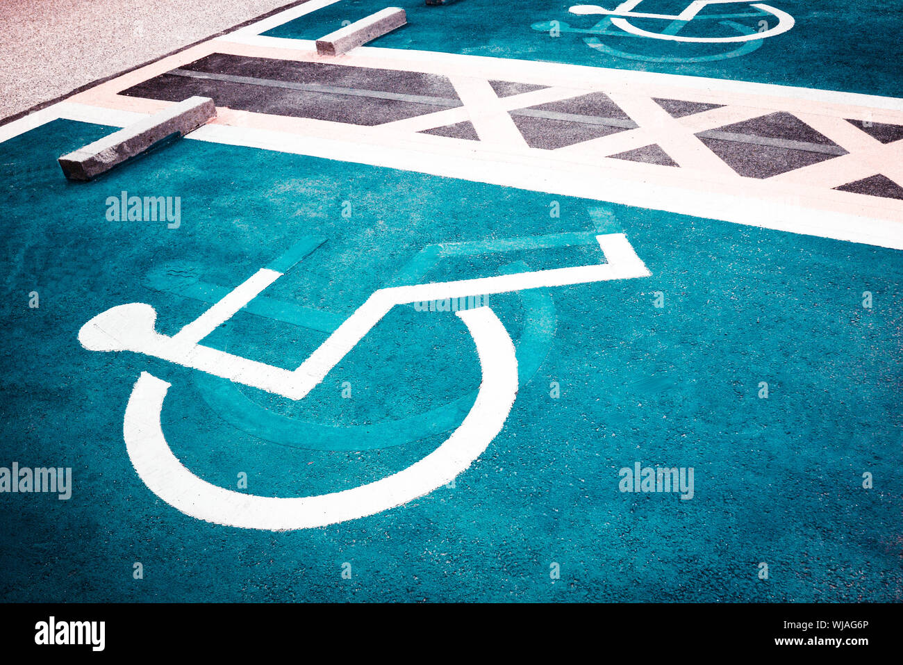 Close-up Of Handicapped Sign On Blue Road Stock Photo