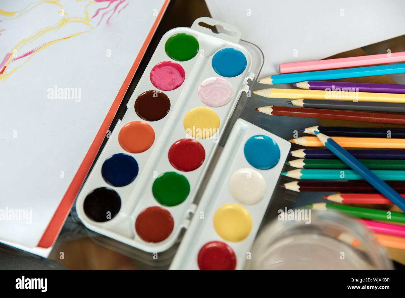 A close up photograph of a box of colorful used chalk pastels