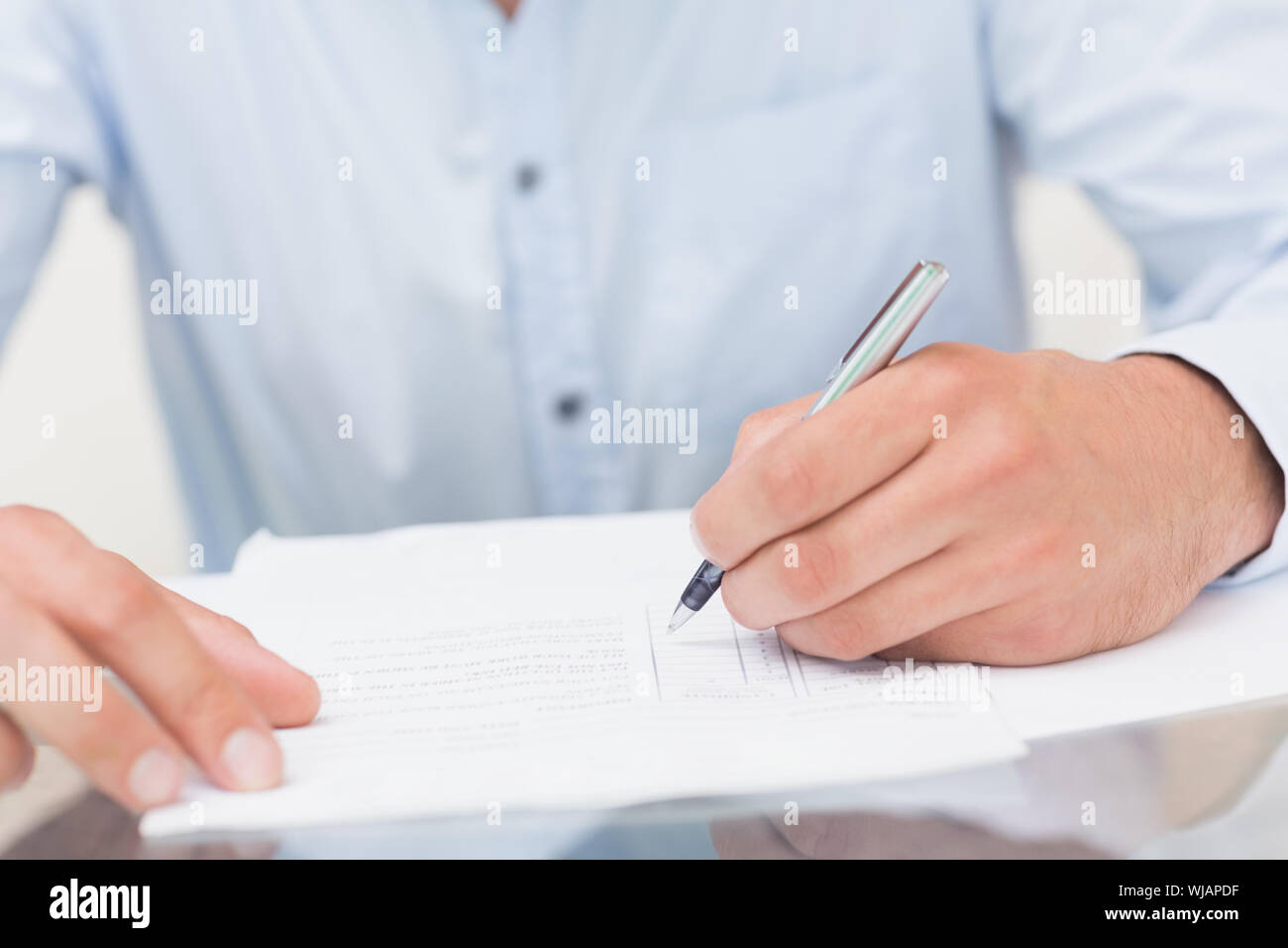 Mid section of a young man writing documents Stock Photo