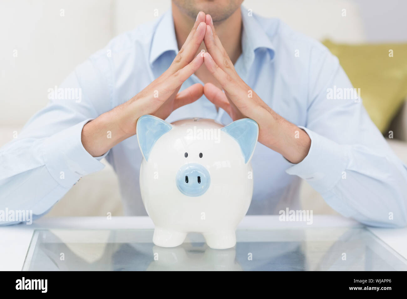 Mid section casual man with piggy bank in living room Stock Photo