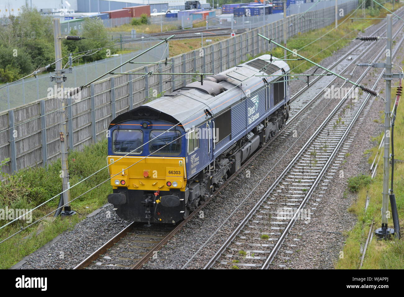 DRS Class 66 diesel locomotive 66303 approaches Daventry International Rail Freight Terminal on the West Coast Main Line Stock Photo