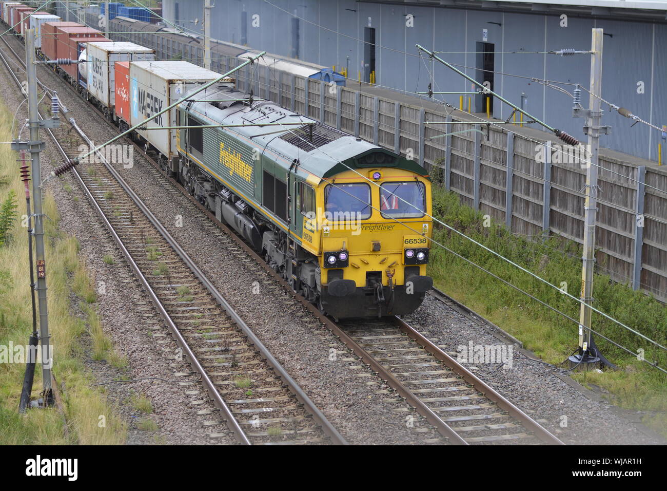 Freightliner Class 66 diesel locomotive 66538 approaches Daventry International Rail Freight Terminal with an intermodal freight train Stock Photo