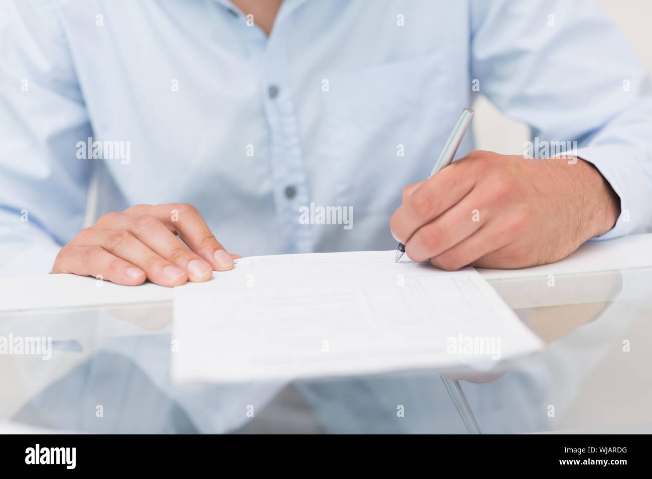 Close-up mid section of a man writing documents Stock Photo
