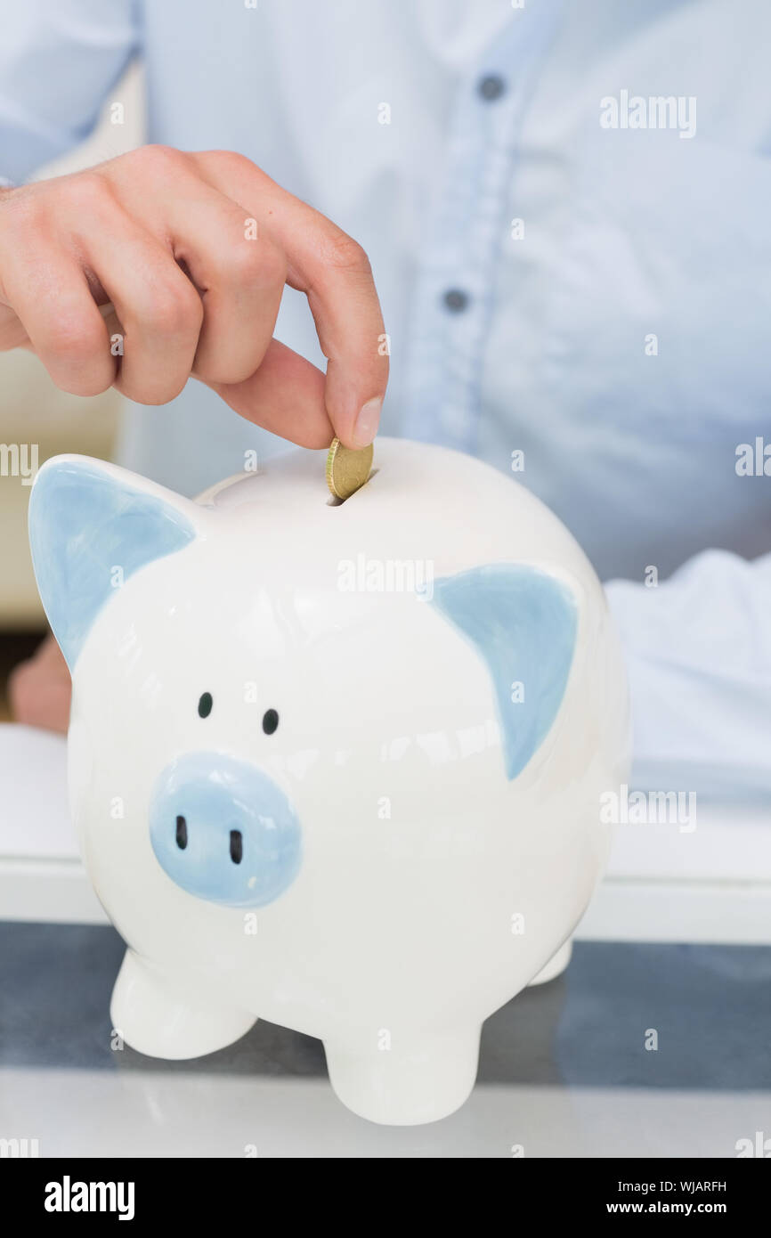 Man putting coin into piggy bank hi-res stock photography and images ...