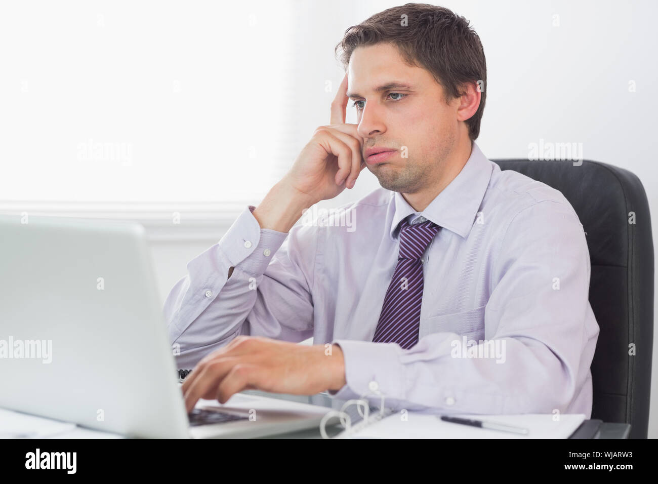 Worried businessman using laptop in office Stock Photo