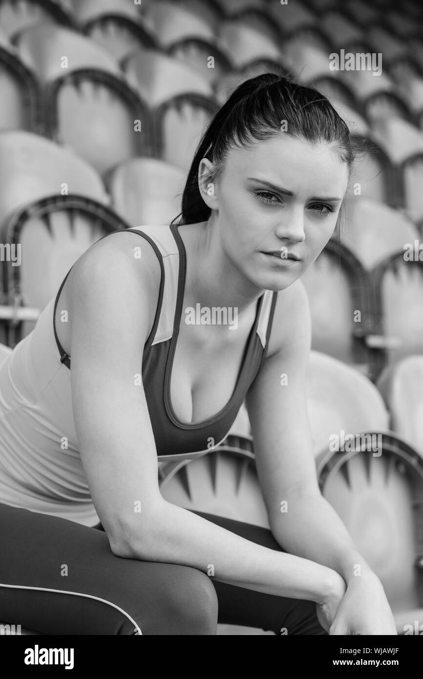 Serious toned woman sitting on chair in the stadium Stock Photo