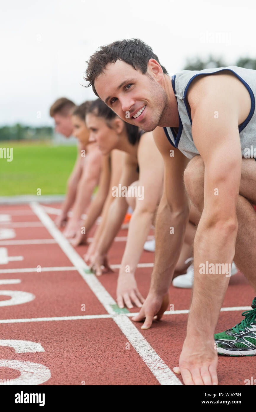 Young people ready to race on track field Stock Photo