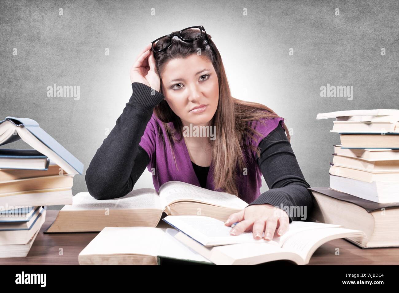 Female with contempt for learning on gray background Stock Photo