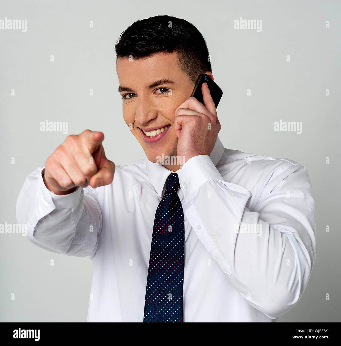 Businessman communicating through mobile and pointing you Stock Photo