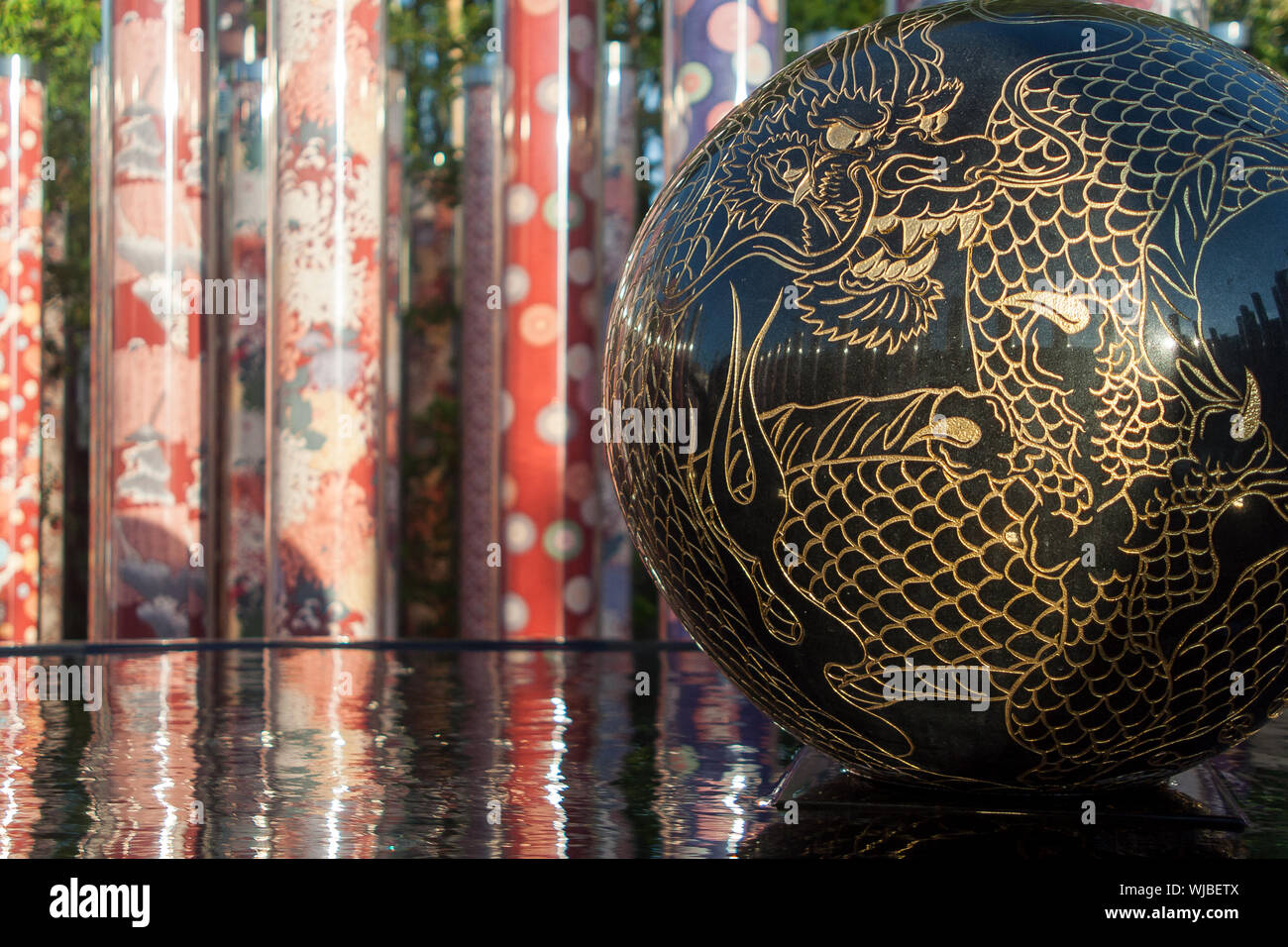 Close-up Of Dragon On Marble Ball Over Water Stock Photo