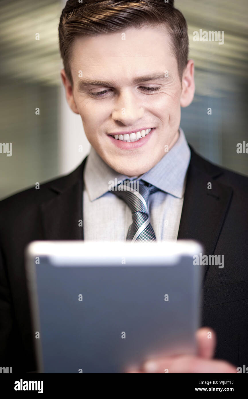 Corporate guy using tablet pc at workplace Stock Photo