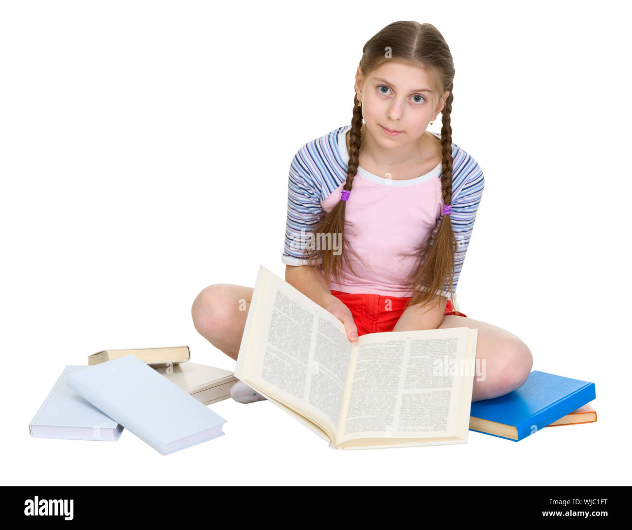 Schoolgirl sitting with a heap of books on a white background Stock ...