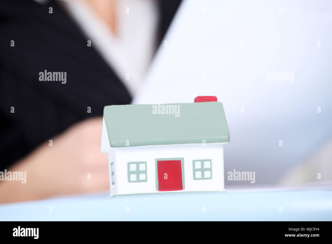 Business woman with small house. Close up Stock Photo - Alamy