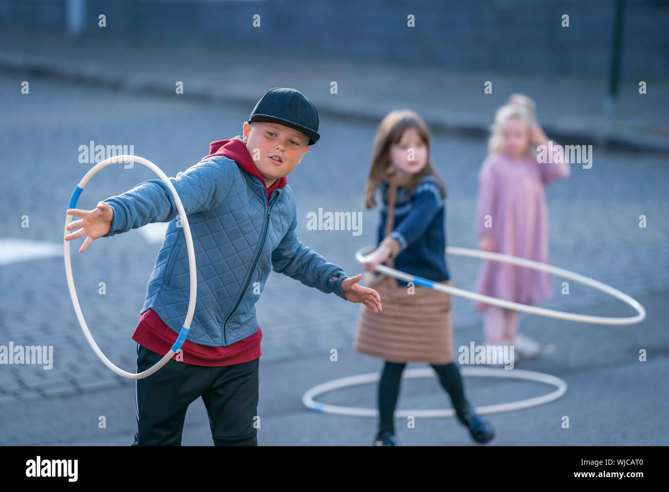 Kids playing with hula hoops, Menningarnott or Cultural day, Reykjavik, Iceland. Street closed off to cars. Stock Photo