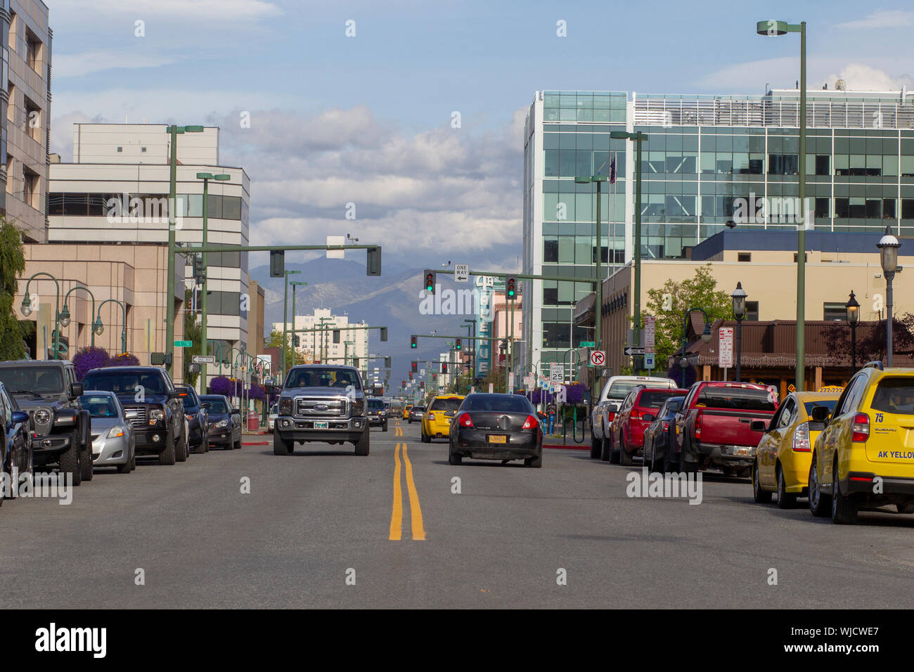 General view of Fourth Avenue downtown Anchorage, Alaska with the Chugach Mountain Range in the background. Stock Photo