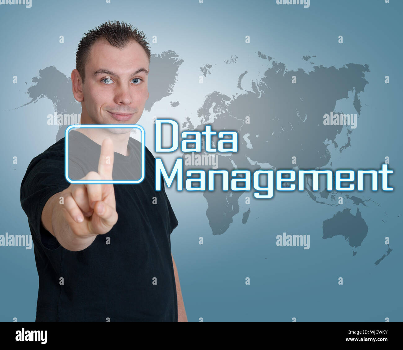 Young man press digital Data Management button on interface in front of him Stock Photo
