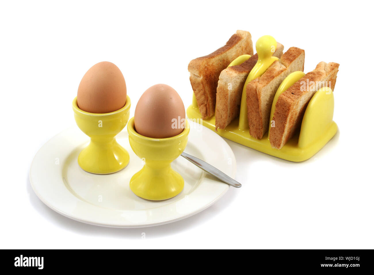 Two boiled eggs and toast with sunshine yellow egg cups and matching
