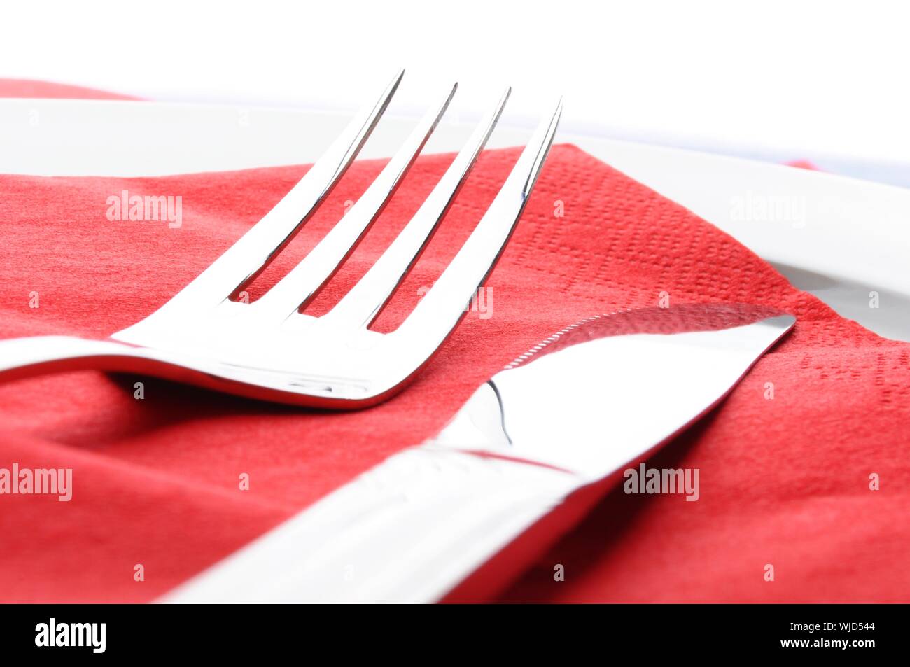 stainless fork knife and plate set on a table Stock Photo - Alamy