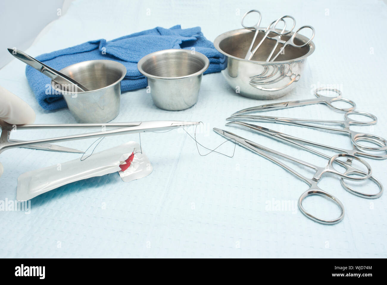 Surgical technician prepares needle holder and suture for use during