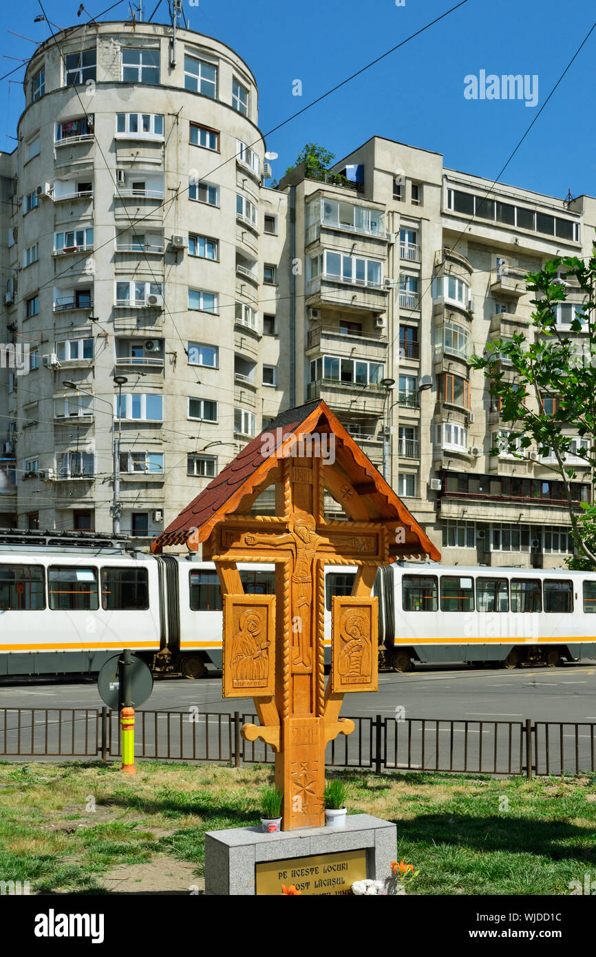 Soviet buildings and a traditional crossroads orthodox cross, Bucharest. Romania Stock Photo