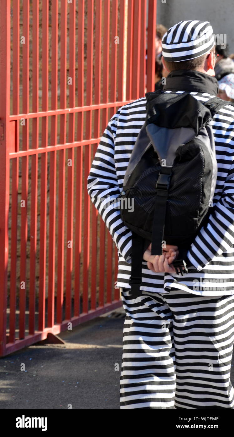 Rear View Of Prisoner With Backpack Walking Out From Prison Stock Photo
