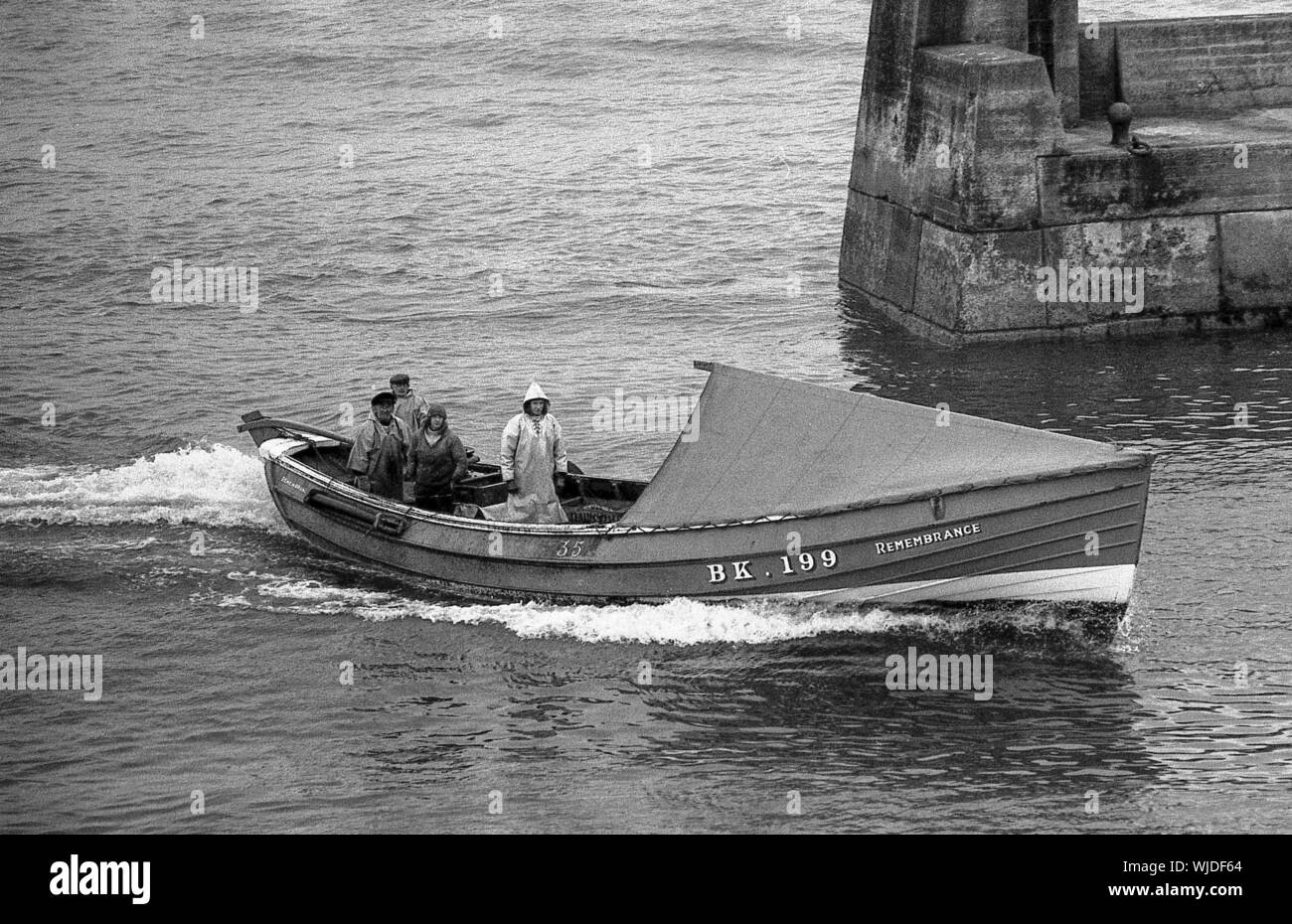 Fishing coble Remembrance entering Seahouses Harbour, Northumberland, c.1972 Stock Photo