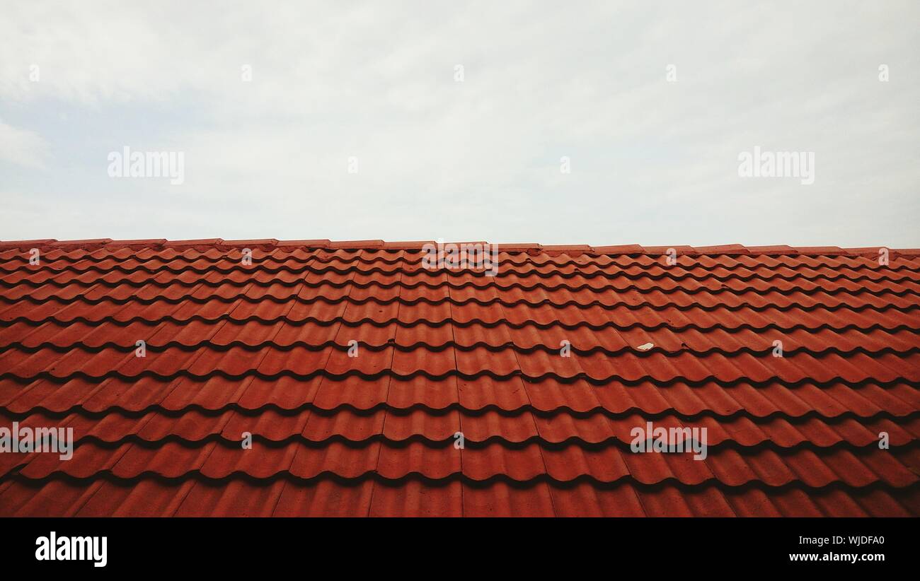 Red Roof Tiles Against Sky Stock Photo