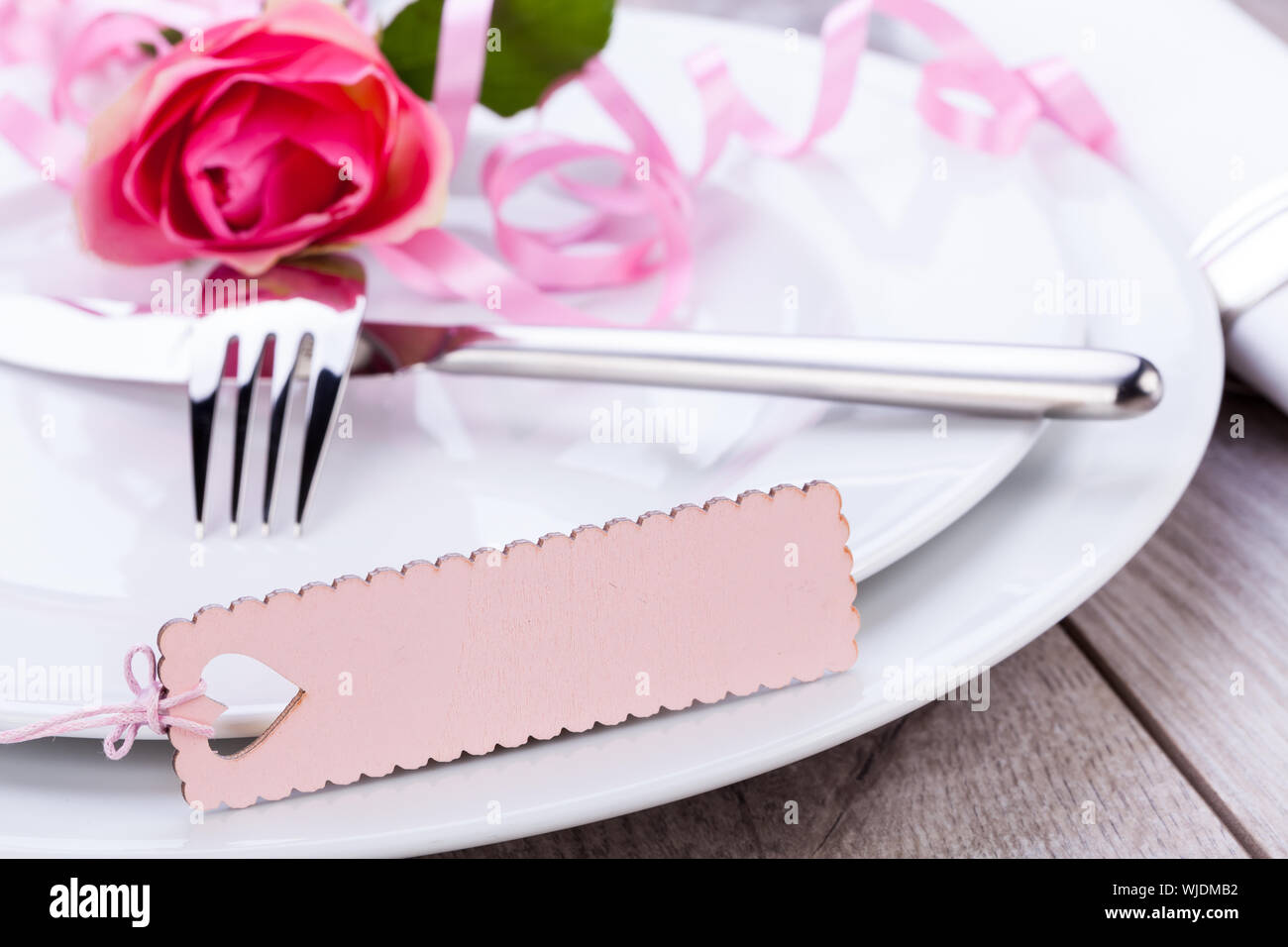 Valentines table setting with an ornamental blank pink gift tag and ...