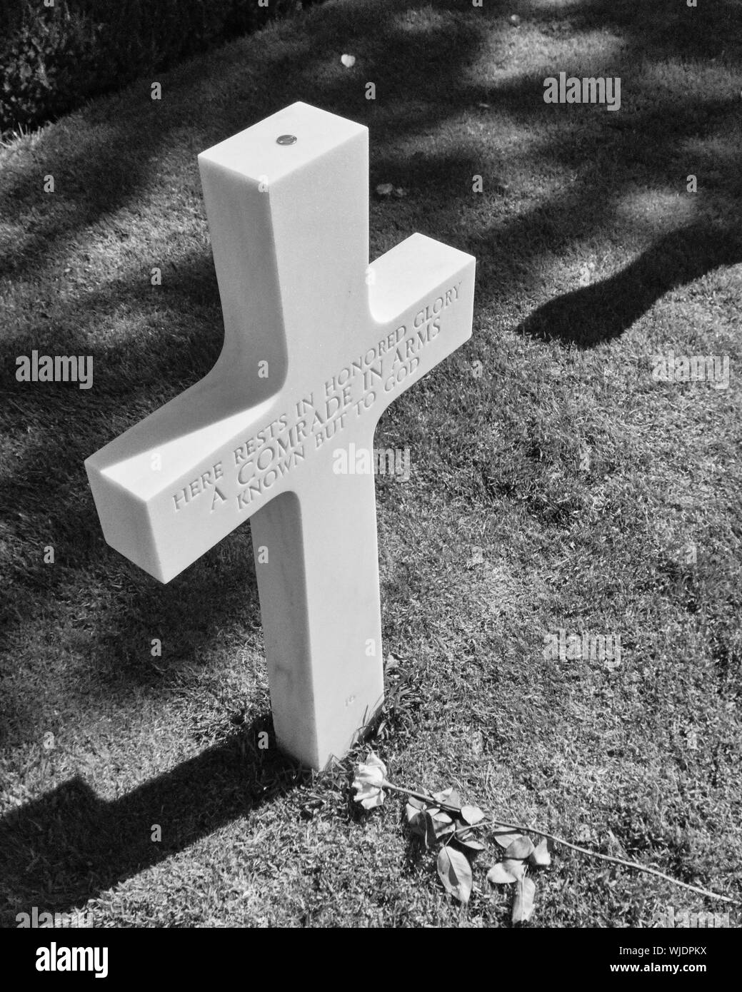 Coin left on top of the cross of an unknown soldier Stock Photo