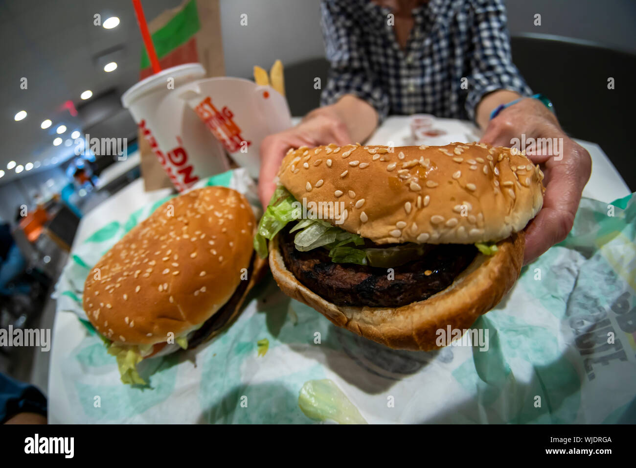 A diner enjoys a Burger King Impossible Whopper, a meatless ground beef  sandwich, in a Burger King restaurant in New York on Tuesday, August 27, 2019. The new menu item uses 1/4 pound of plant-based food made by Impossible Foods. (© Richard B. Levine) Stock Photo