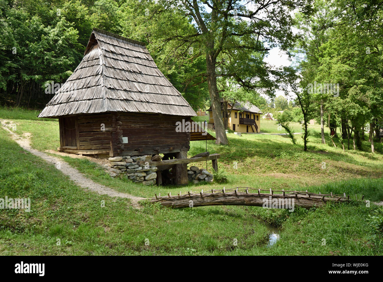 Traditional watermill and bridge made from a tree trunk. Prigor, Caras-Severin county. ASTRA Museum of Traditional Folk Civilization, an open-air muse Stock Photo
